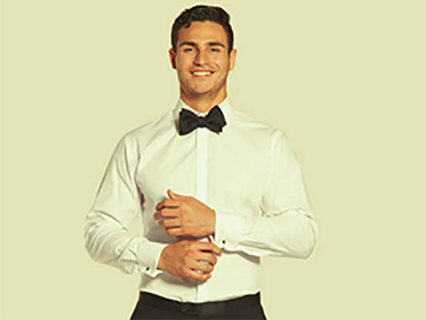 man dressed in a formal white shirt with a bow-tie adjusting his cuffs and smiling